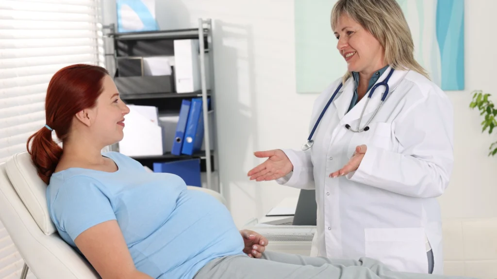 Pregnant woman consulting doctor about early pregnancy scan in Birmingham clinic
